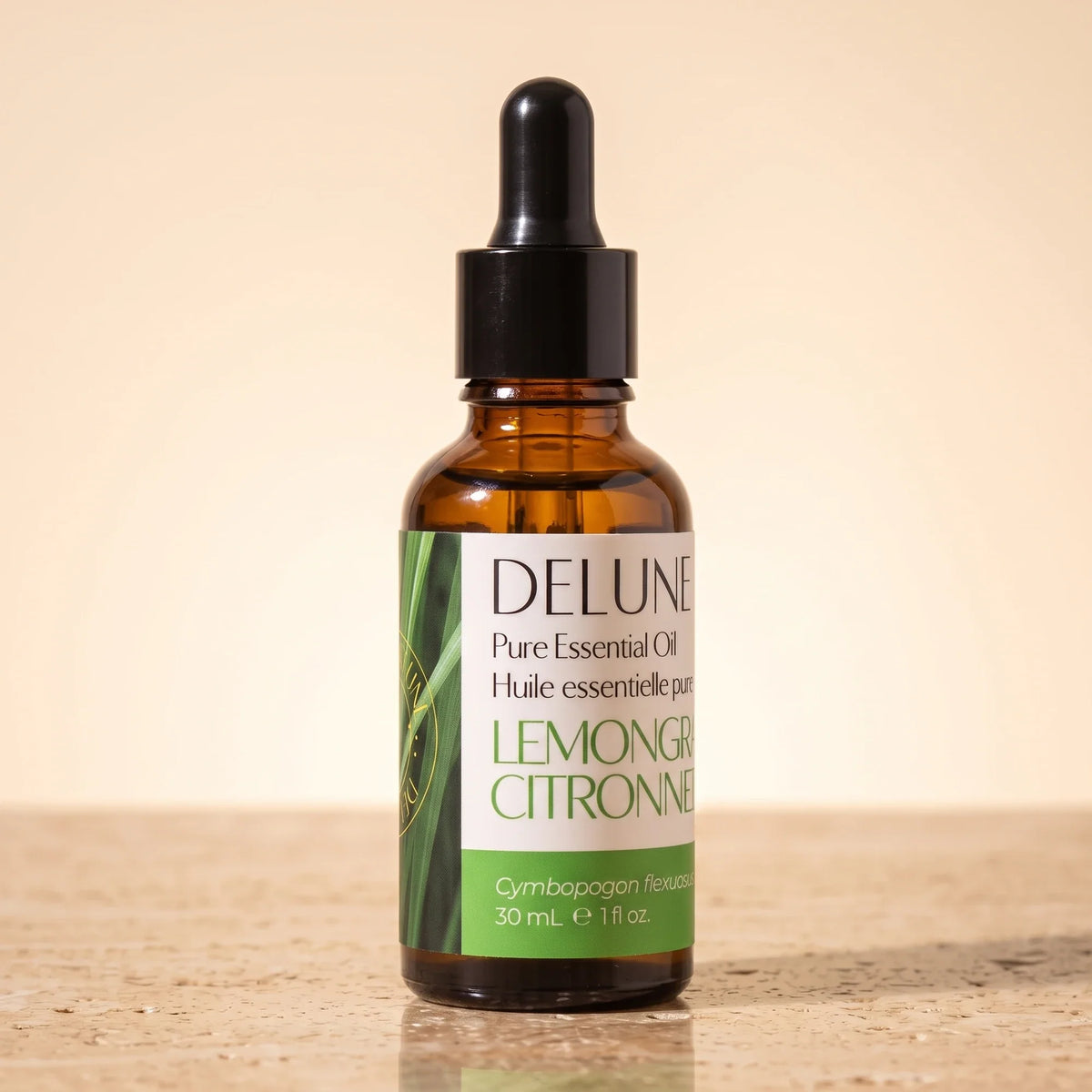 Delune Citrongræs – ren æterisk olie, 30 ml ravfarvet pipetteflaske på varm travertin