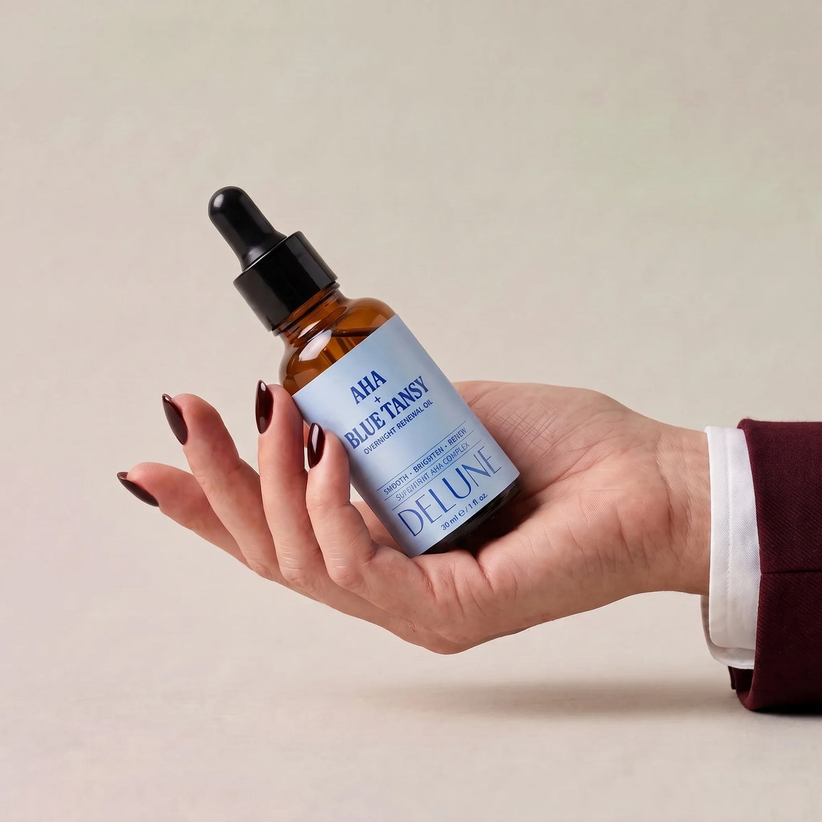 Delune AHA + Blue Tansy natolie til fornyelse i en åben hånd