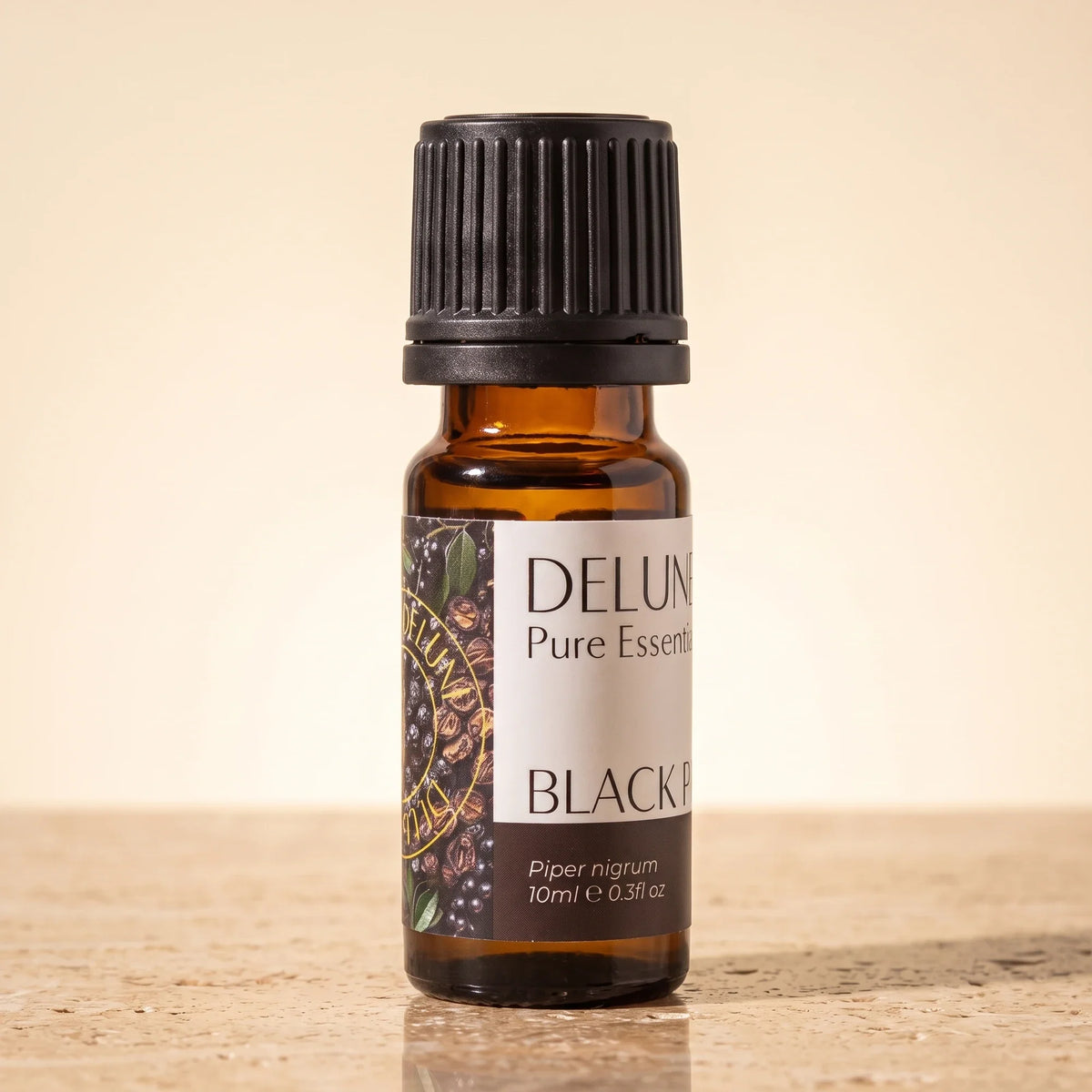 Delune Sort peber – ren æterisk olie, 10 ml ravfarvet glasflaske på varm travertin
