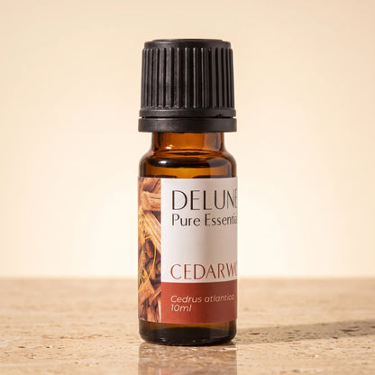 Delune Cedertræ – ren æterisk olie, 10 ml ravfarvet glasflaske på varm travertin