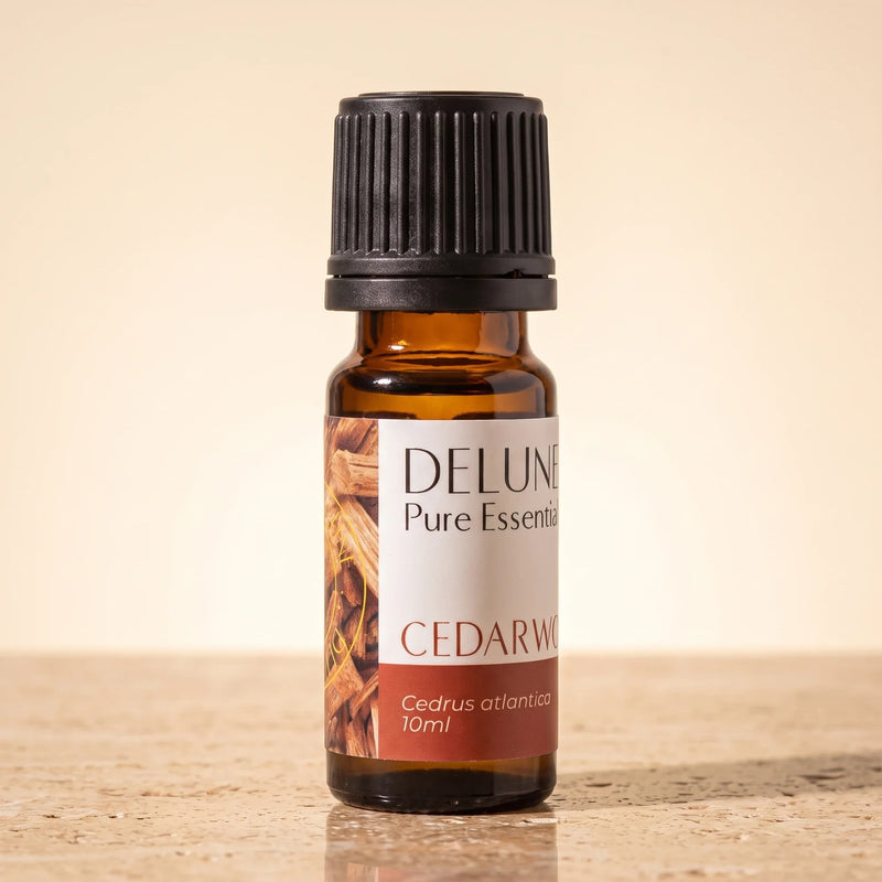 Delune Cedertræ – ren æterisk olie, 10 ml ravfarvet glasflaske på varm travertin