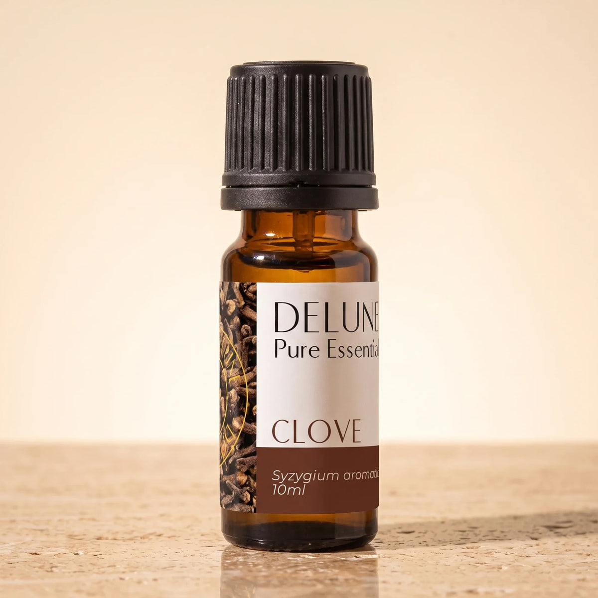 Delune Nellike – ren æterisk olie, 10 ml ravfarvet glasflaske på varm travertin