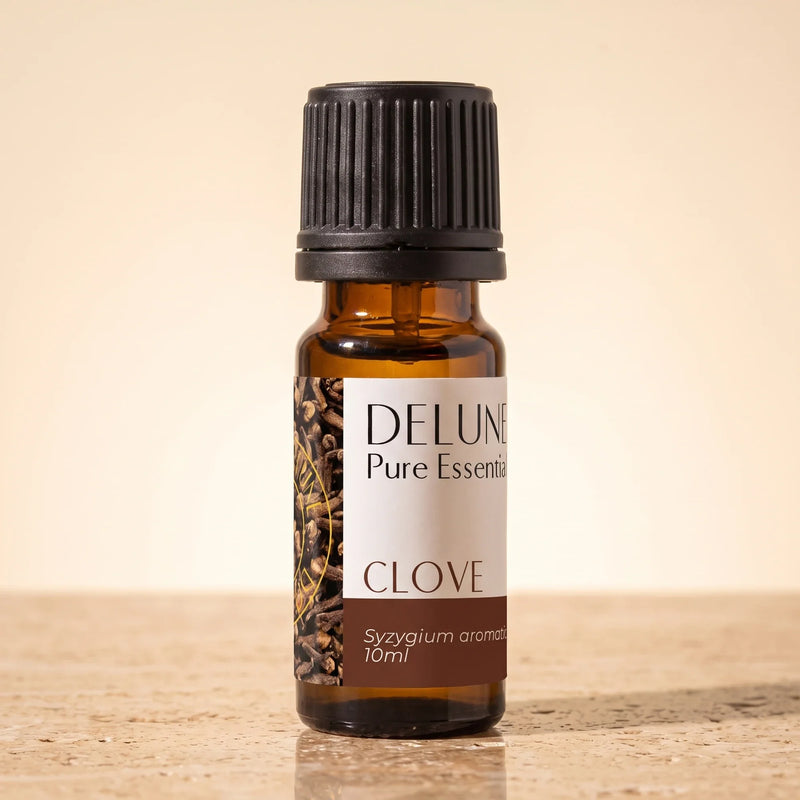 Delune Nellike – ren æterisk olie, 10 ml ravfarvet glasflaske på varm travertin