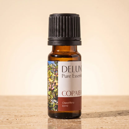Delune Copaiba – ren æterisk olie, 10 ml ravfarvet glasflaske på varm travertin