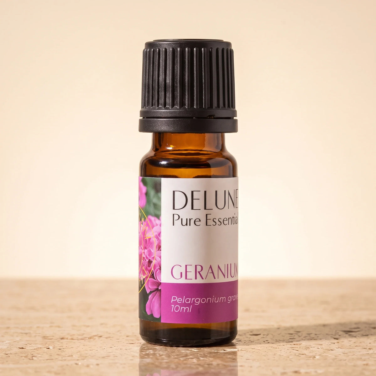 Delune Geranium – ren æterisk olie, 10 ml ravfarvet glasflaske på varm travertin