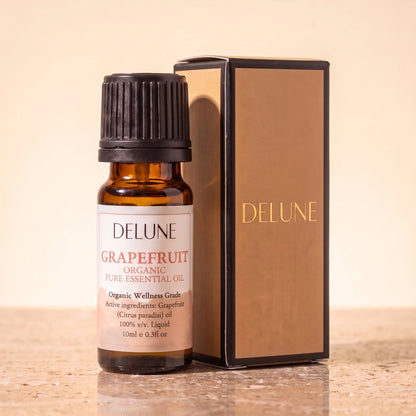 Delune Grapefrugt – Organic Wellness Grade æterisk olie, 10 ml ravfarvet glasflaske med gaveæske i guldfolie på varm travertin