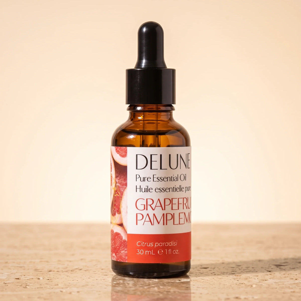 Delune Lyserød grapefrugt – ren æterisk olie, 30 ml ravfarvet pipetteflaske på varm travertin