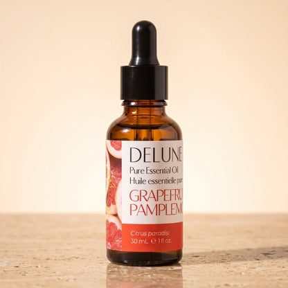 Delune Lyserød grapefrugt – ren æterisk olie, 30 ml ravfarvet pipetteflaske på varm travertin