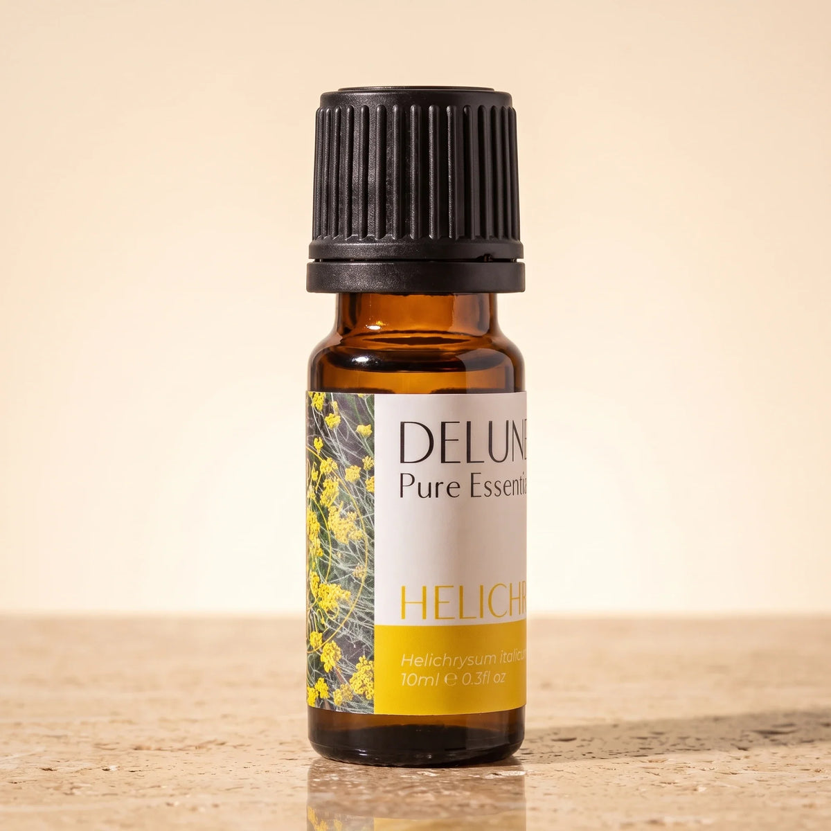 Delune Helichrysum (Immortelle) – ren æterisk olie, 10 ml ravfarvet glasflaske på varm travertin
