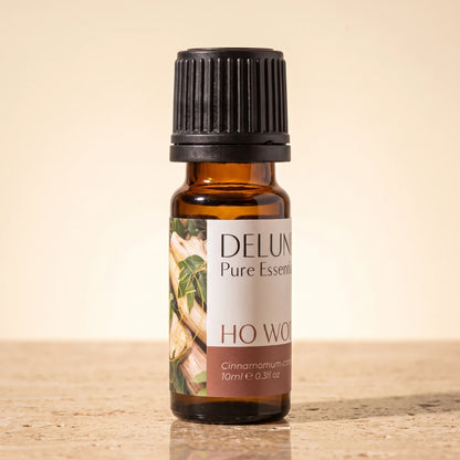 Delune Ho-træ – ren æterisk olie, 10 ml ravfarvet glasflaske på varm travertin