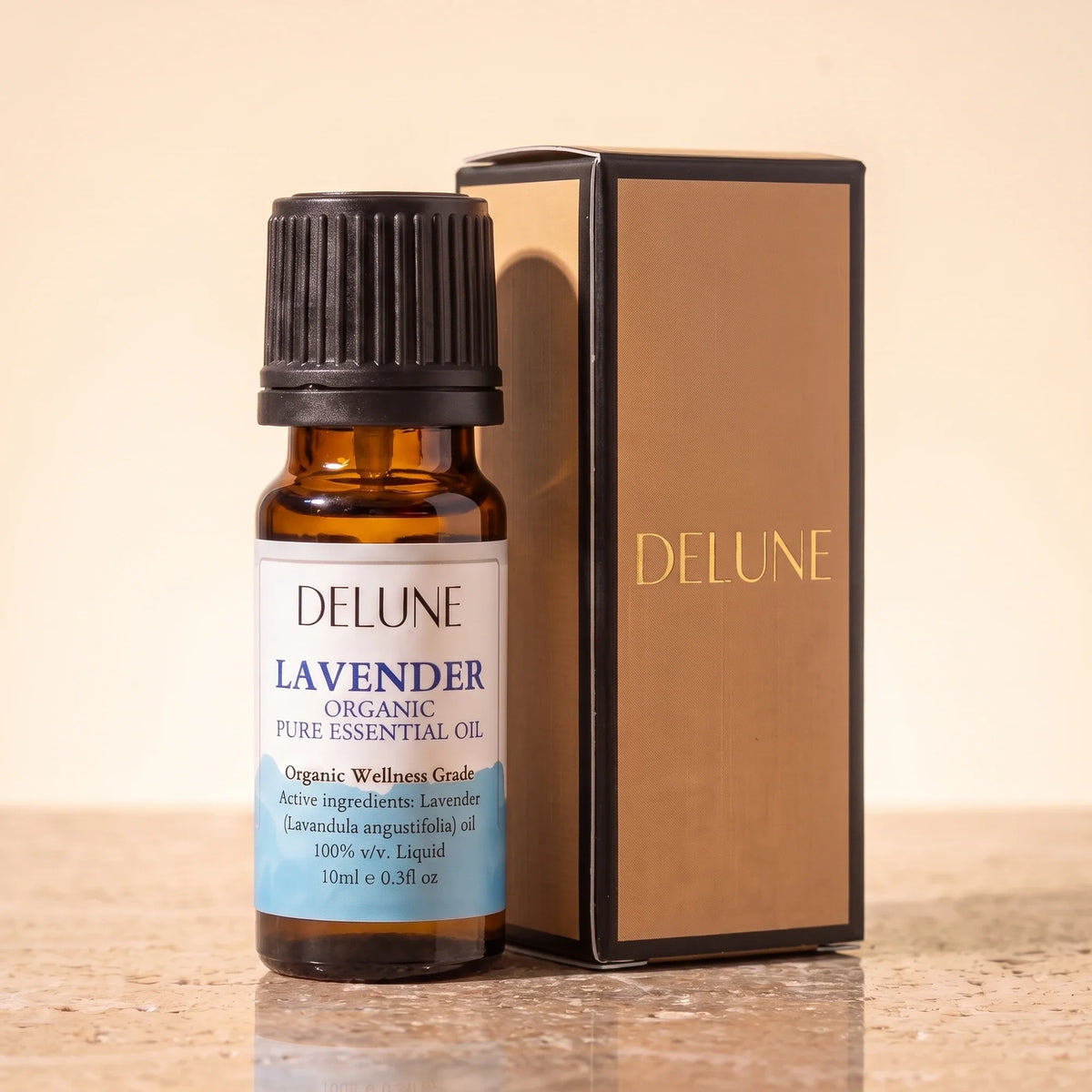 Delune Lavendel – Organic Wellness Grade æterisk olie, 10 ml ravfarvet glasflaske med gaveæske i guldfolie på varm travertin