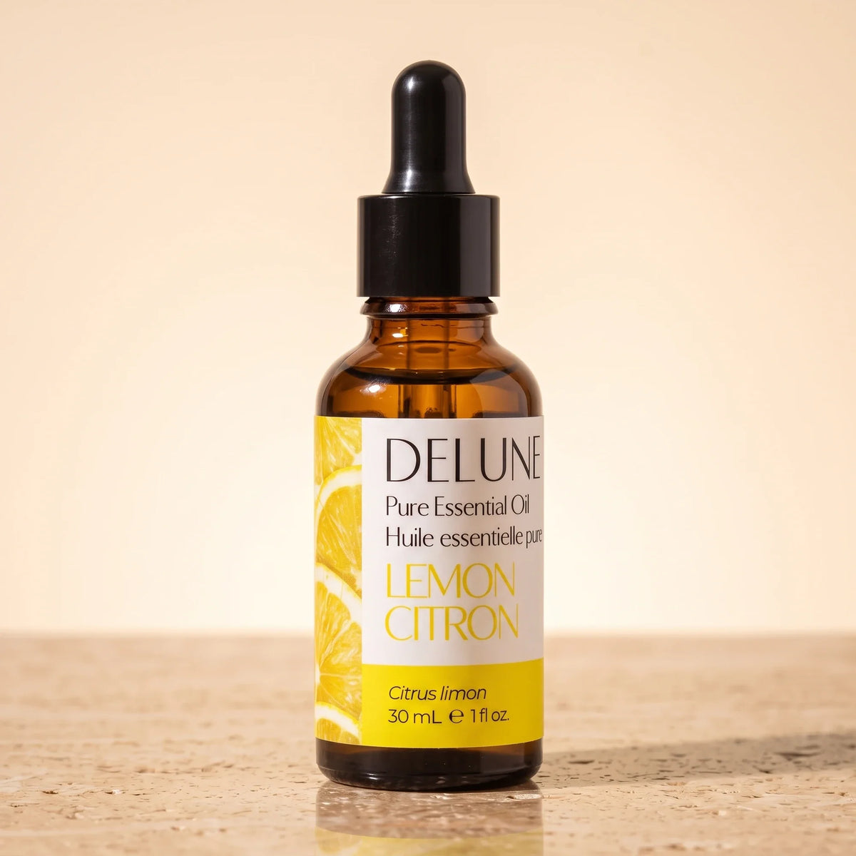 Delune Citron – ren æterisk olie, 30 ml ravfarvet pipetteflaske på varm travertin
