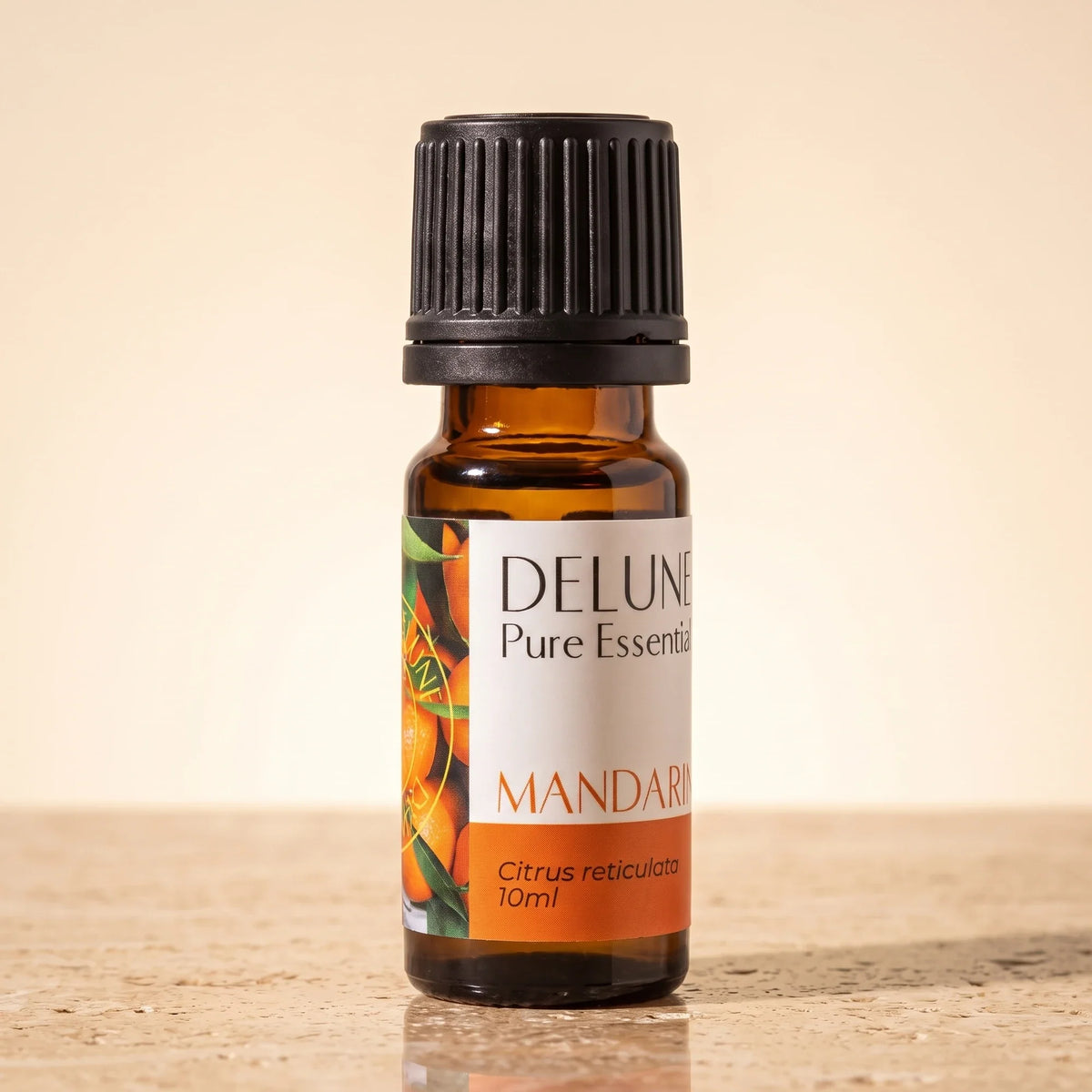 Delune Mandarin – ren æterisk olie, 10 ml ravfarvet glasflaske på varm travertin