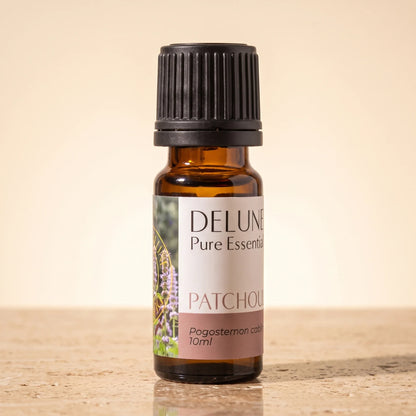 Delune Patchouli – ren æterisk olie, 10 ml ravfarvet glasflaske på varm travertin