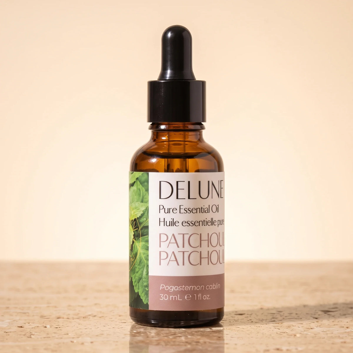 Delune Patchouli – ren æterisk olie, 30 ml ravfarvet pipetteflaske på varm travertin