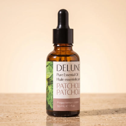 Delune Patchouli – ren æterisk olie, 30 ml ravfarvet pipetteflaske på varm travertin
