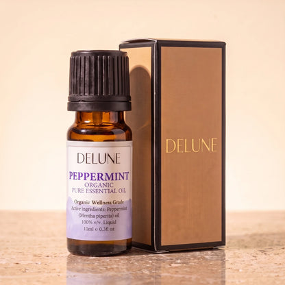 Delune Pebermynte – Organic Wellness Grade æterisk olie, 10 ml ravfarvet glasflaske med gaveæske i guldfolie på varm travertin