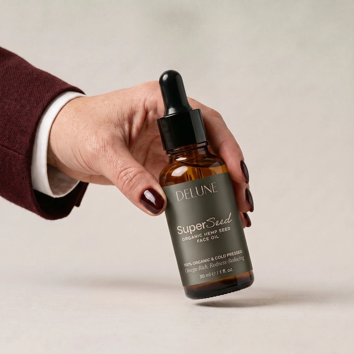 Hånd, der tager Super Seed – ansigtsolie med hampefrø fra Delune