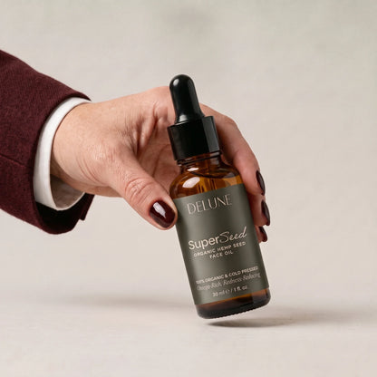 Hånd, der tager Super Seed – ansigtsolie med hampefrø fra Delune