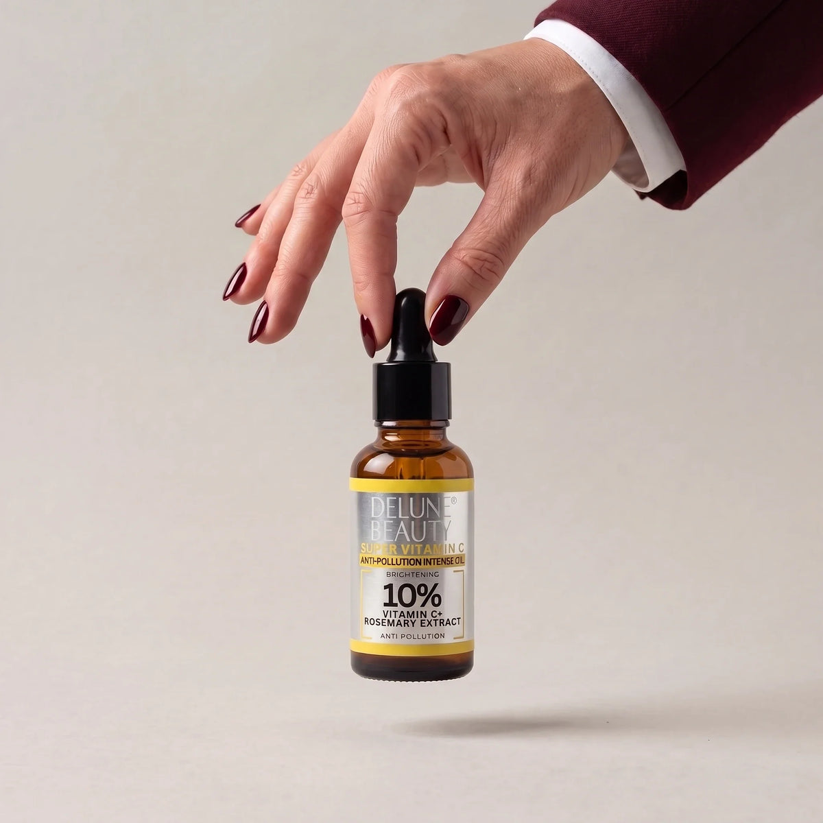 Hånd, der løfter Super Vitamin C™ opklarende olie fra Delune